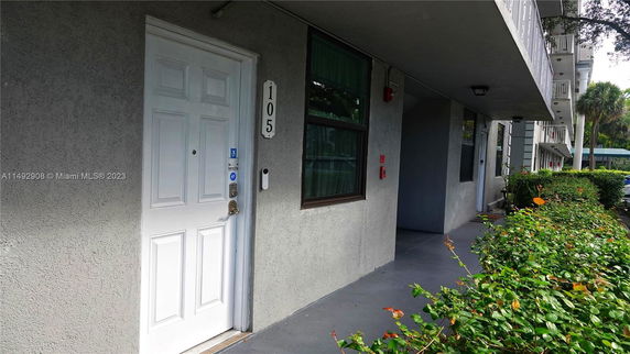 Front view of a multi-story building with a white door marked 105.