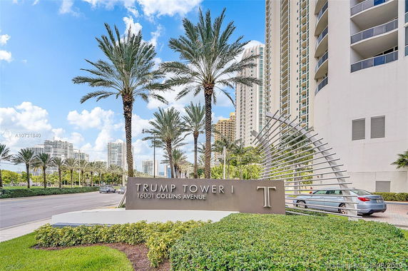 Front view of a multi-story building with palm trees and a sign labeled Trump Tower I.