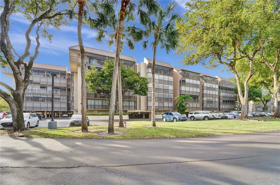 Front view of a multi-story apartment building with balconies.