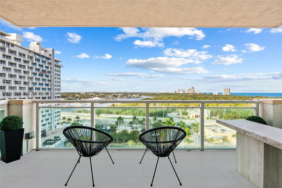 View from a balcony overlooking a cityscape and distant coastline.