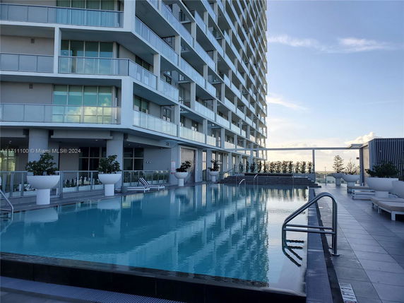 Rooftop with a swimming pool adjacent to a modern multi-story building.