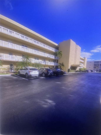 Front view of a multi-story building with a parking area.