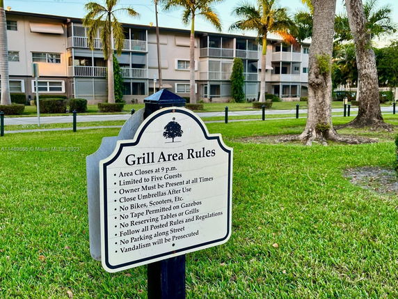 Exterior view of a multi-story building with balconies and palm trees in front.