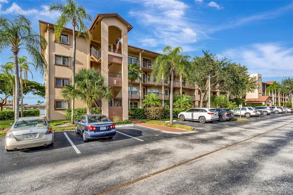 Outdoor parking area in front of a multi-story residential building.