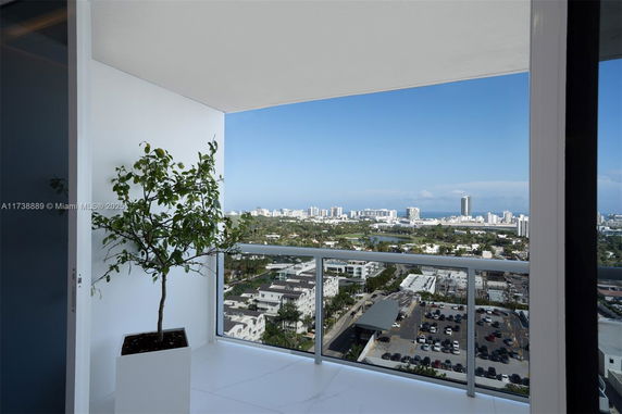 View from a high-rise balcony with cityscape in the distance.