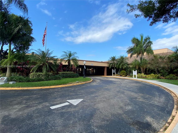 Front view of a single-story building with an entrance drive and landscaped surroundings.