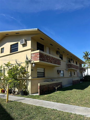 Front view of a two-story apartment building with balconies.
