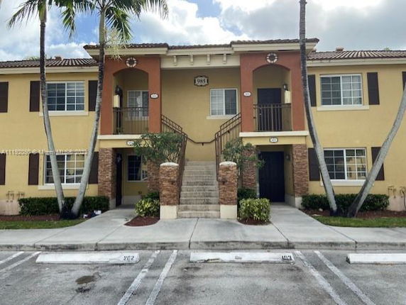 Front view of a two-story building with a central staircase leading to upper units.