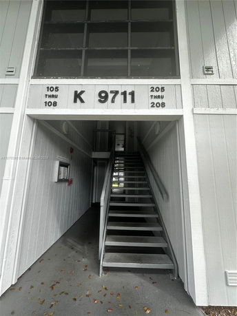 Front view of a building entrance with a staircase leading to upper floors.