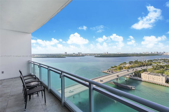 View from a balcony overlooking a body of water and a bridge.