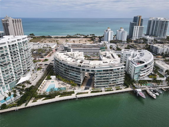 Aerial view of a waterfront building complex near the ocean.