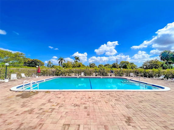 Outdoor swimming pool with surrounding patio area and lounge chairs.