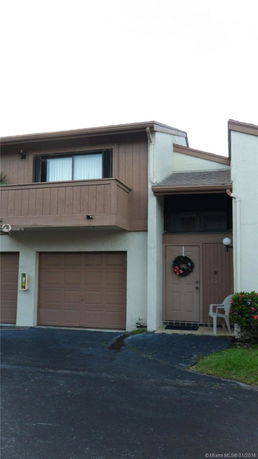 Front view of a two-story house with a garage and a small balcony.