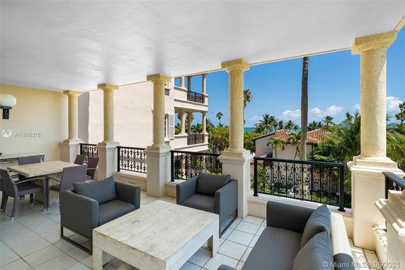 Balcony view showing distant buildings and lush greenery.