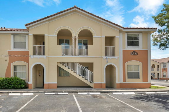 Front view of a two-story building with arches and balconies.
