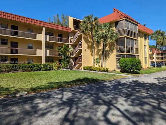 Front view of a multi-story apartment building with balconies and red tiled roofs.