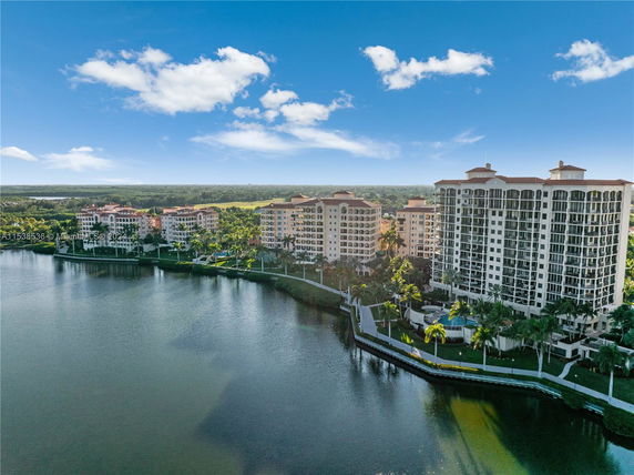 Aerial view of multiple multi-story apartment buildings near a lake.