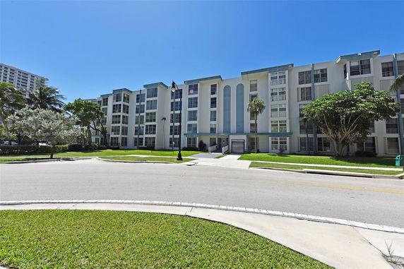 Front view of a multi-story apartment building with balconies and a modern design.