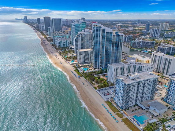 Aerial view of beachfront high-rise buildings along the coastline.
