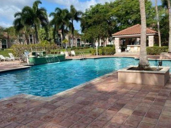 Outdoor swimming pool with surrounding patio and trees.