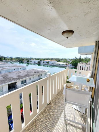 Balcony view overlooking residential buildings and a body of water.