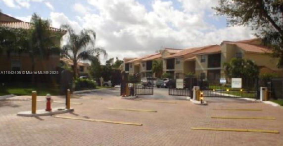 Front view of a gated residential complex with multiple buildings.
