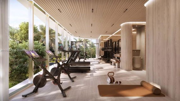 Indoor gym area with exercise equipment and large windows.