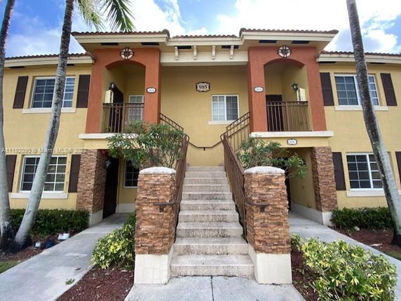Front view of a two-story residential building with external staircase.