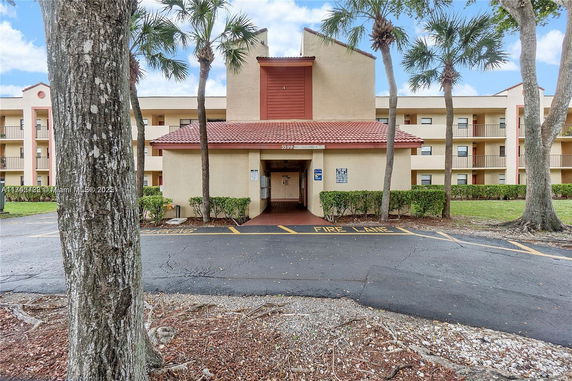Front view of a multi-story building with a tiled roof and exterior walkways.