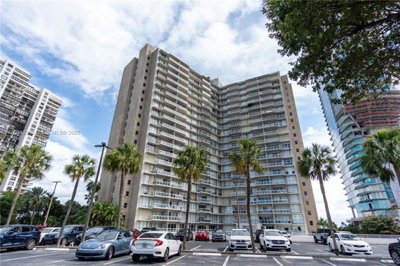Front view of a high-rise residential building with multiple balconies.