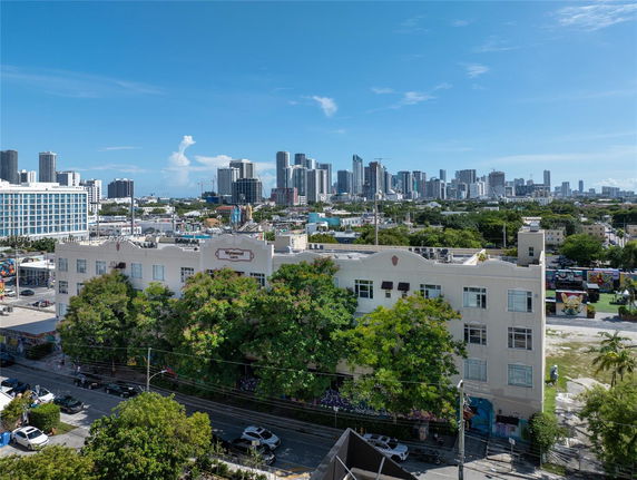 Aerial view of a mid-rise building with city skyline in the background.