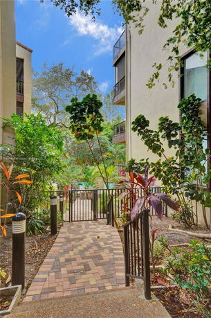 View of garden area between buildings with paved walkway and plants.