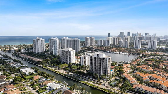 Panoramic view of high-rise buildings and waterfront area with ocean in the background.