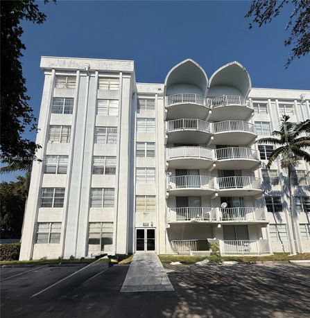 Front view of a multi-story apartment building with balconies.