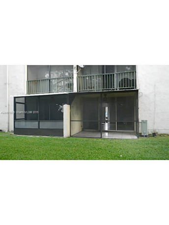 Rear view of a multi-story building with screened balconies.