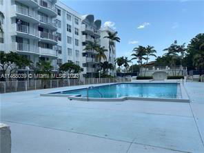 Outdoor swimming pool area adjacent to a multi-story building.