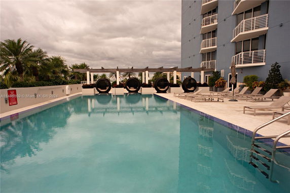 Outdoor swimming pool area with lounge chairs and circular seating.