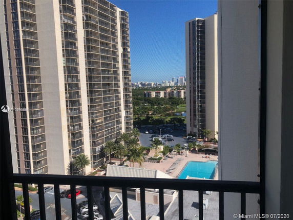 View from a balcony showing multiple high-rise buildings and a swimming pool.