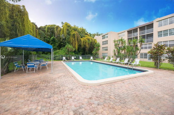 Outdoor swimming pool area with lounge chairs and a canopy.