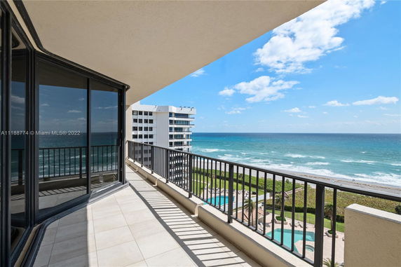 View from a balcony overlooking the ocean and adjacent buildings.