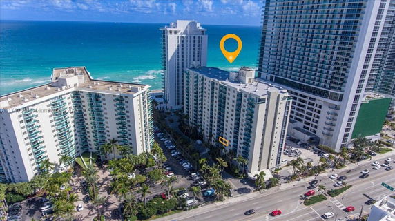 Aerial view of tall beachfront buildings with balconies.