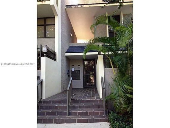 Entrance view of a multi-story building with steps leading to the main door.
