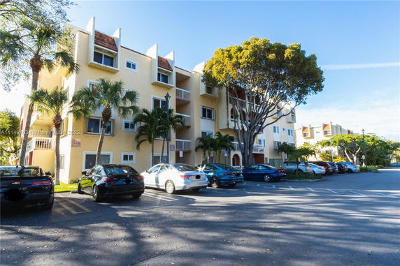 Outdoor parking area in front of a multi-story residential building.