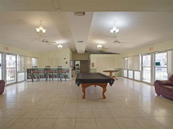 Indoor recreation area with pool table and bookshelves.