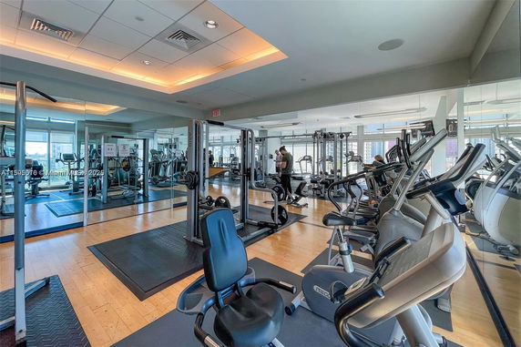 Indoor gym area with various exercise equipment and mirrored walls.