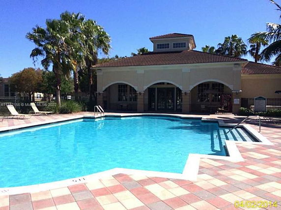 Outdoor swimming pool area with a building in the background.