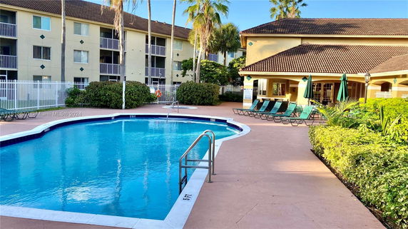 Outdoor swimming pool area with a surrounding building.