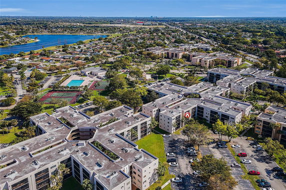 Aerial view of residential complex with multiple buildings and a swimming pool.