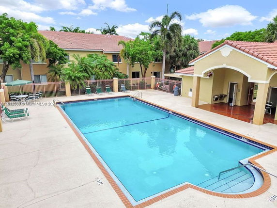 Outdoor swimming pool area with surrounding buildings.