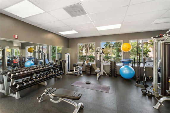 Gym area with exercise equipment including weights, machines, and fitness balls.